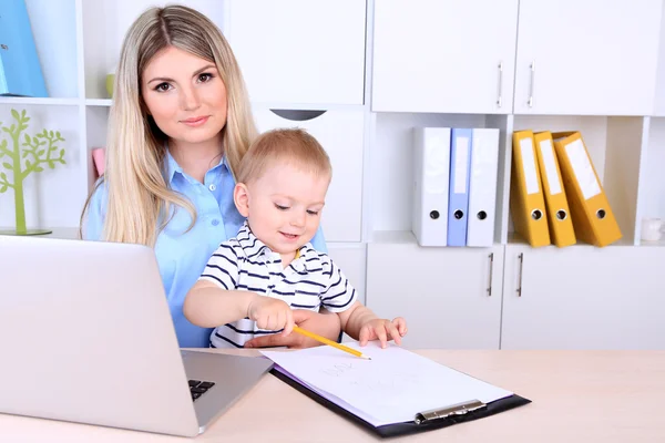 Pretty woman with baby working at home — Stock Photo, Image