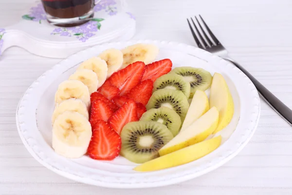 Varios frutos en rodajas en el plato en primer plano de la mesa —  Fotos de Stock