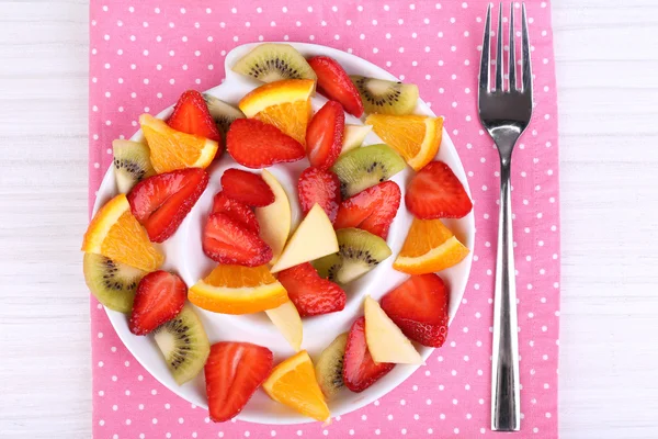 Verschillende gesneden fruit op plaat op tabel close-up — Stockfoto