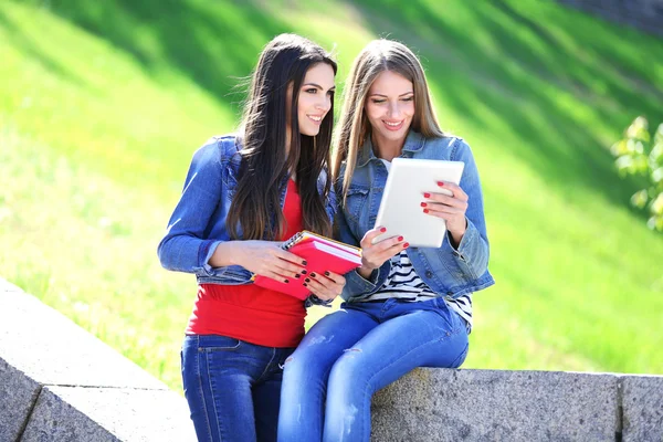 Estudantes felizes sentados no parque — Fotografia de Stock