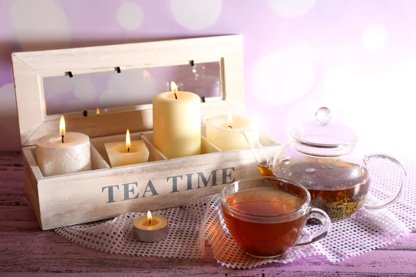 Összetétele a tea-cup és a teáskanna és a gyertyák, a tábla, a világos háttér — Stock Fotó