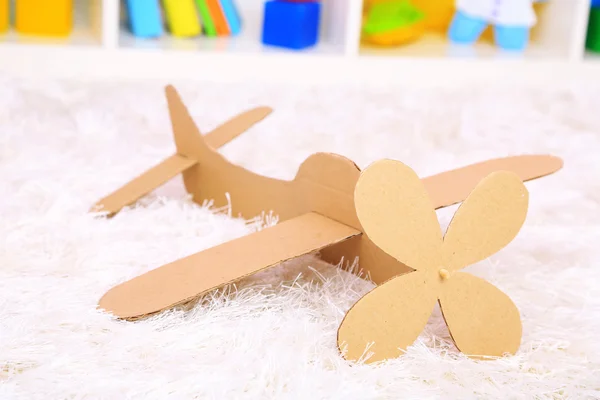 Brinquedo de avião de papel no quarto no tapete — Fotografia de Stock