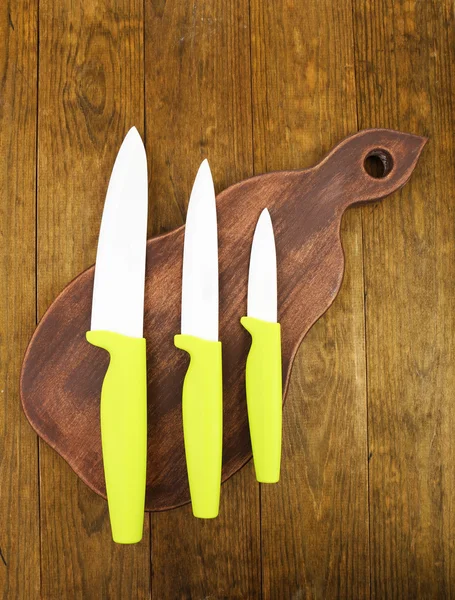 Kitchen knives and cutting board on wooden table — Stock Photo, Image