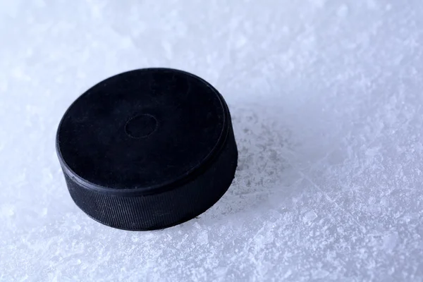 Puck de hockey negro sobre fondo de pista de hielo —  Fotos de Stock