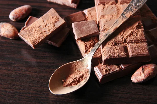 Kakao och mörk choklad på färg trä bakgrund — Stockfoto