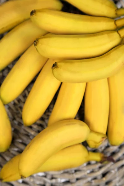 Bando de mini bananas no fundo esteira de vime — Fotografia de Stock