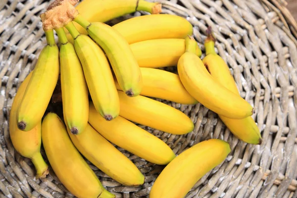 Bando de mini bananas no fundo esteira de vime — Fotografia de Stock