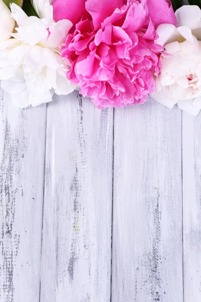 Mooie roze en witte pioenrozen op een houten achtergrond kleur — Stockfoto