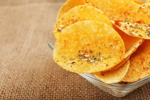 Hemlagade potatischips i glasskål på bord — Stockfoto