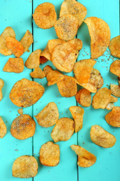 Homemade potato chips on color wooden table — Stock Photo, Image