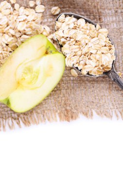 Alma zabpehely és vintage kanállal, elszigetelt fehér 