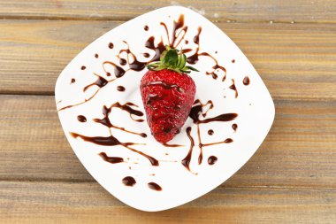 ahşap masa üstünde çikolata ile kırmızı olgun çilek