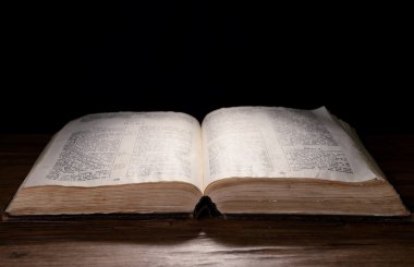 siyah arka plan üzerine masada eski kitap