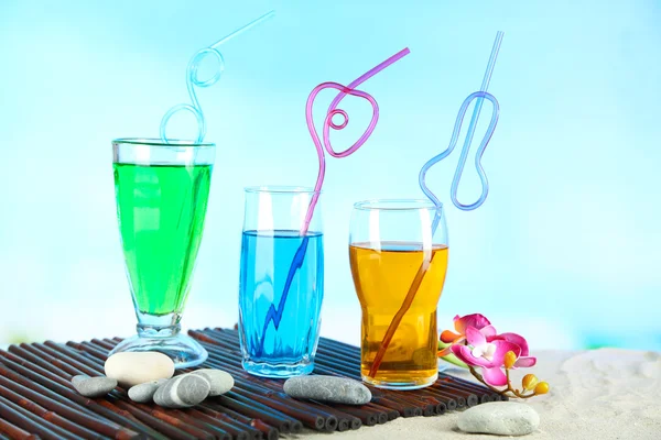 Glazen cocktails op zand, op lichte achtergrond — Stockfoto
