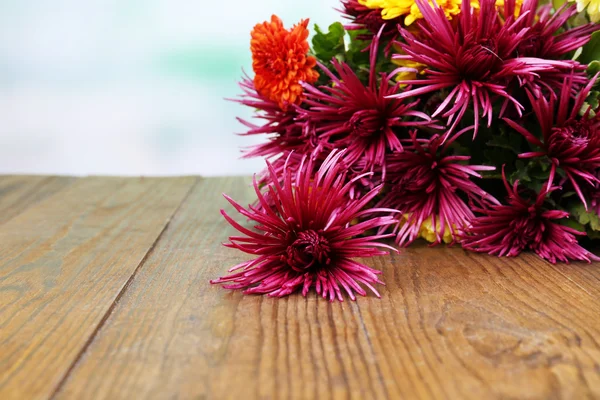 Beautiful flowers on wooden table,  on bright background — Stock Photo, Image