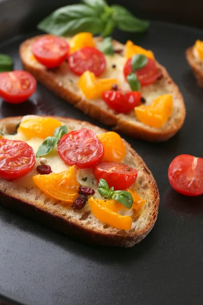 Tasty bruschetta with tomatoes in pan, close up — Stock Photo, Image