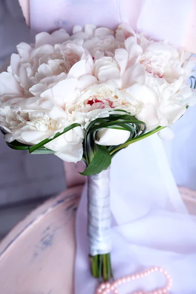 Красивый свадебный букет на деревянном стуле на светлом фоне — стоковое фото