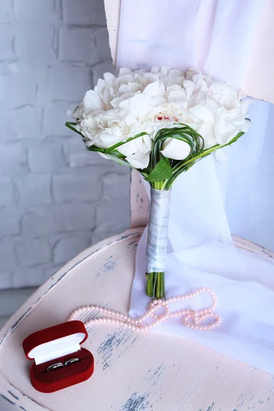 Krásné svatební kytice na dřevěné židli na světlé pozadí — Stock fotografie