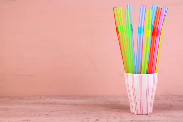 Straws in cup on pink background — Stock Photo, Image