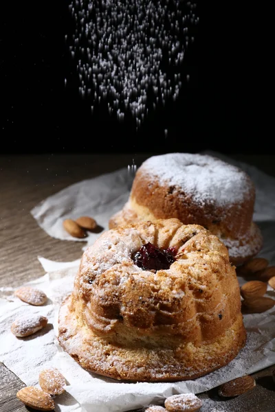 Leckere Kuchen auf dem Tisch auf schwarzem Hintergrund — Stockfoto