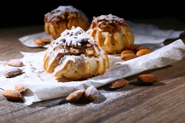 Leckere Kuchen auf dem Tisch auf schwarzem Hintergrund — Stockfoto