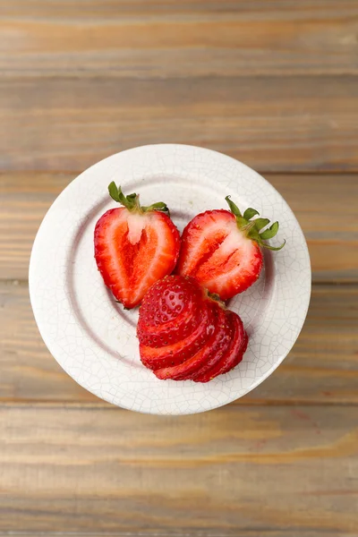 Rote reife Erdbeeren auf hölzernem Hintergrund — Stockfoto