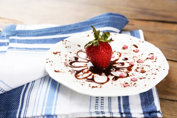 Red ripe strawberry with chocolate on wooden table — Stock Photo, Image