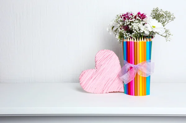 Mooie bloemen in kleurrijke potloden vaas in het interieur — Stockfoto