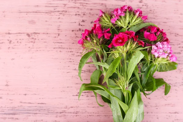Krásnou kytici s mašlí na dřevěné pozadí — Stock fotografie