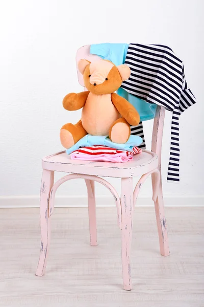 Ropa en silla sobre fondo de pared gris — Foto de Stock