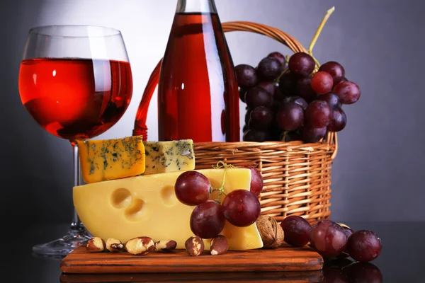 Vino rosa, uvas y queso sobre fondo colorido —  Fotos de Stock