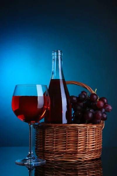 Uvas maduras, copa de vino y botella de vino sobre fondo colorido —  Fotos de Stock