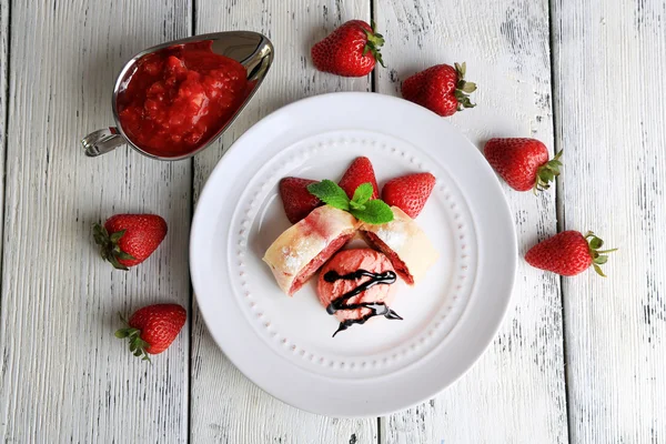 Chutné domácí štrúdl s-zmrzlina, čerstvé jahody a mátou listy na talíř, na dřevěné pozadí — Stock fotografie