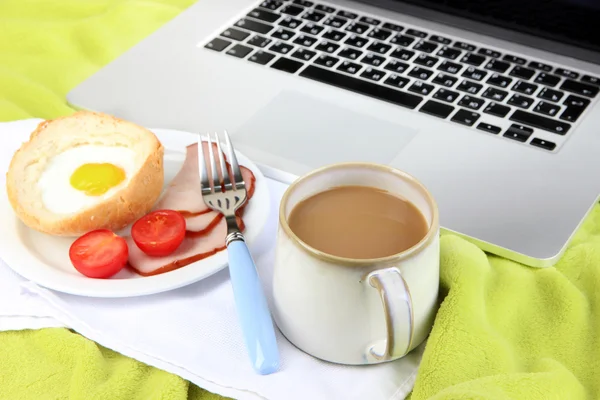 Composition with laptop and tasty breakfast on wooden tray, close-up, on color plaid background — Stock Photo, Image