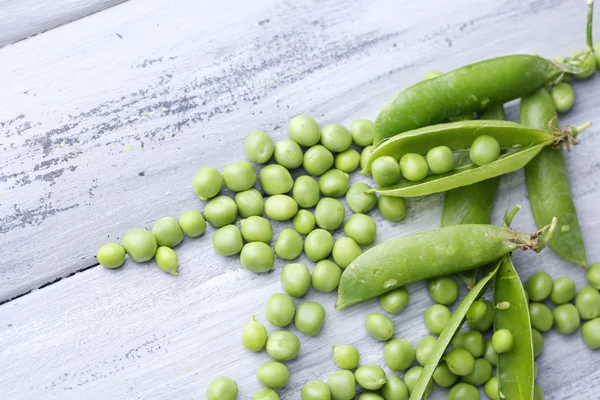 Fresh green peas on wooden background — Stock Photo, Image