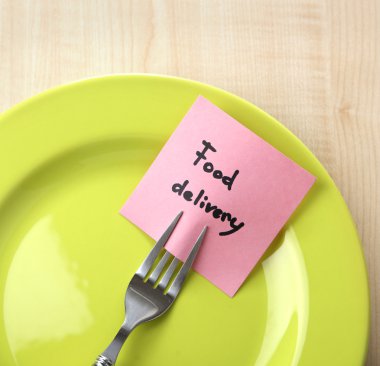 Not kağıdı çatalı tabağa renk ahşap arka plan üzerinde ekli mesajla