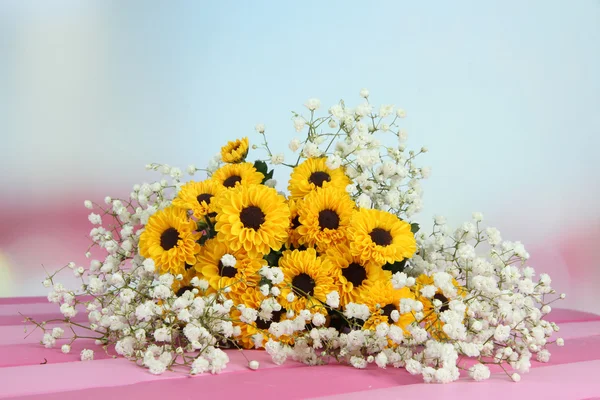 Lindas flores na mesa no fundo brilhante — Fotografia de Stock