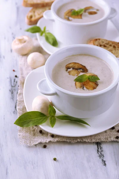 Pilzsuppe in weißen Töpfen, auf Serviette, auf Holzgrund — Stockfoto