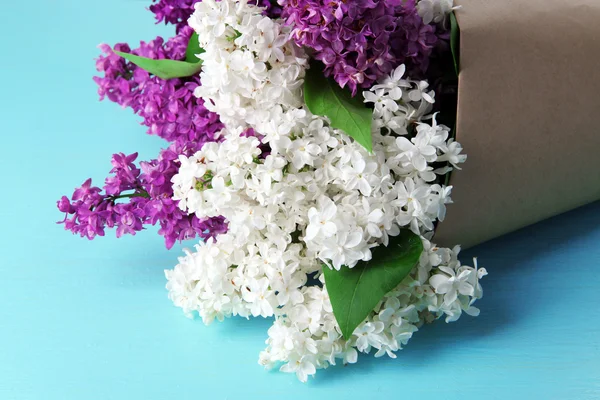 Beautiful bouquet of lilac flowers on color wooden background — Stock Photo, Image