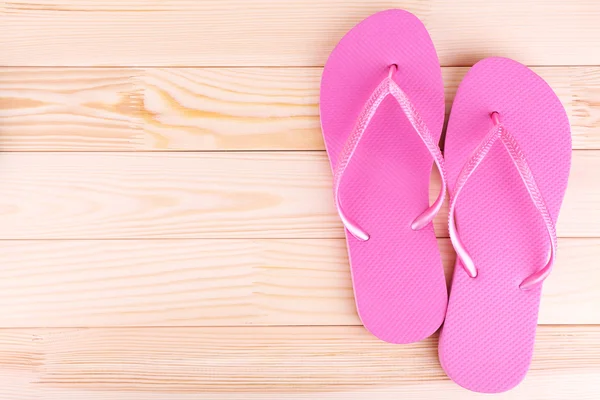 Bright flip-flops on wooden background — Stock Photo, Image