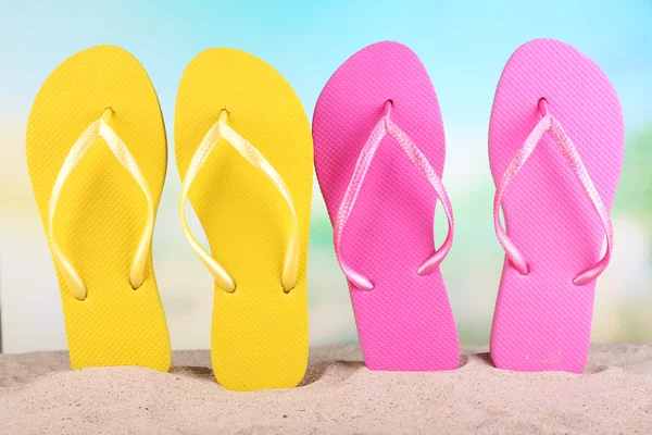 Bright flip-flops on sand, on nature background — Stock Photo, Image