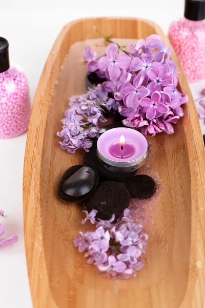 Sammansättning med spa-behandling, trä skål med vatten, handduk och lila blommor, isolerad på vit — Stockfoto