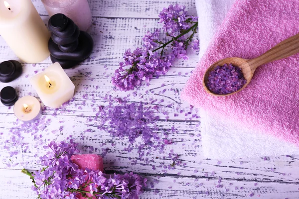 Composizione con trattamento spa, asciugamani e fiori lilla, su fondo chiaro — Foto Stock