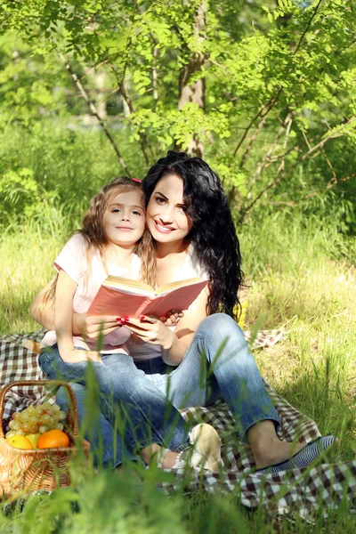 Happy mom and daughter. Picnic in the green park — Stock Photo, Image