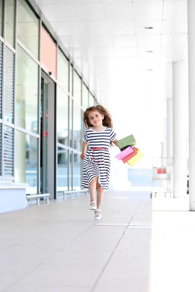 Счастливая маленькая девочка с сумками, на открытом воздухе — стоковое фото
