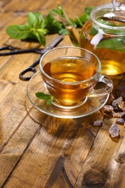 Taze nane çayı cam bardak ve ahşap zemin üzerine çaydanlık bileşimi