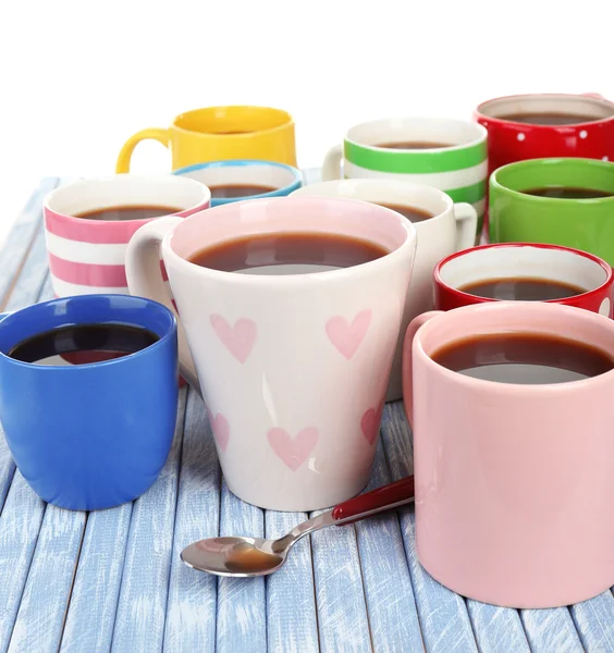 Muitas xícaras de café em mesa de madeira isolada em branco — Fotografia de Stock