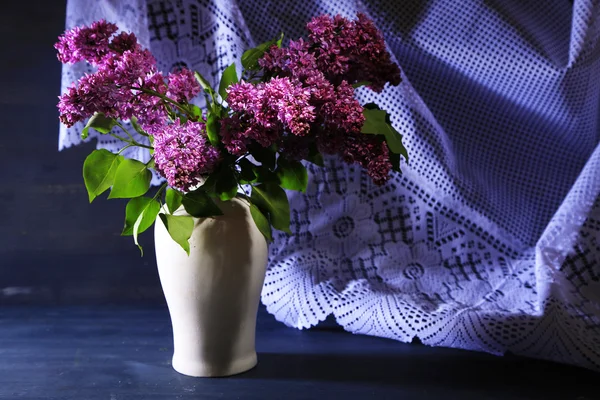 Güzel Eflatun çiçekler vazoda renkli ahşap zemin üzerinde — Stok fotoğraf