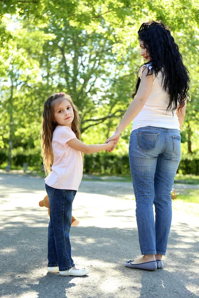 Feliz mamá y su hija. Caminar por el parque verde — Foto de Stock
