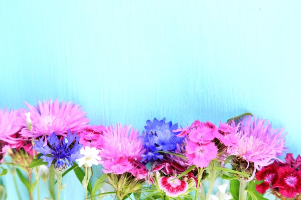 Heldere wilde bloemen op een houten achtergrond kleur — Stockfoto